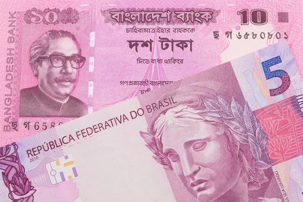 stock image A macro image of a pink and purple five real bank note from Brazil paired up with a pink ten taka bank note from Bangladesh.  Shot close up in macro.