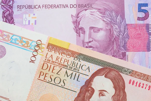 ブラジルのピンクと紫の5つの本物の銀行券のマクロ画像は コロンビアの茶色の1万枚の銀行券と対になりました マクロでショットを閉じる — ストック写真