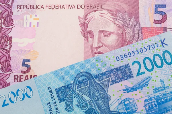 一张来自巴西的粉色和紫色五张真实钞票的宏观图片 与一张蓝色的2000西非法郎钞票搭配在一起 在宏观上拍的特写 — 图库照片