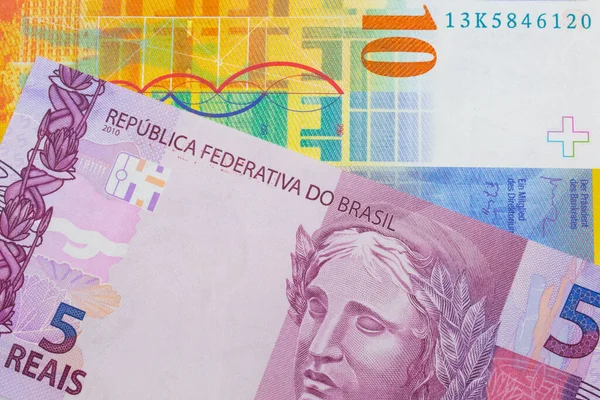 一张巴西面额为粉色和紫色的5张真实钞票的宏观图片 与一张黄色的10瑞士法郎钞票搭配在一起 在宏观上拍的特写 — 图库照片