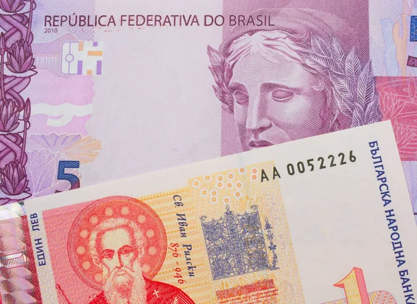 ブラジルのピンクと紫の5本の本物の銀行券のマクロ画像は ブルガリアの赤と白の1本のレフ銀行券と対になりました マクロでショットを閉じる — ストック写真