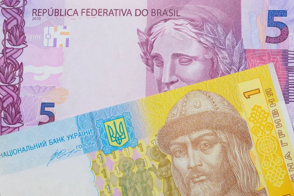 一张巴西面额为粉色和紫色的5张真实钞票的宏观图片 与乌克兰面额为蓝色 白色和黄色的一张透明质钞票搭配在一起 在宏观上拍的特写 — 图库照片