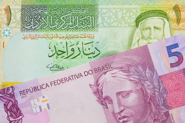 ブラジルのピンクと紫の5つの本物の銀行券のマクロ画像は ヨルダンからの緑と黄色の1ディナール紙幣と対になりました マクロでショットを閉じる — ストック写真