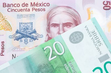 Meksika 'dan gelen 50 pezoluk pembe bir banknotun makro görüntüsü, Sırbistan' dan gelen yeşil ve beyaz bir 20 dinar banknotla eşleştirildi. Makro çekimde yakın çekim.