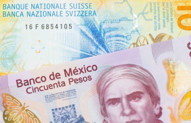 Meksika 'dan gelen 50 pezoluk pembe bir banknotun makro görüntüsü sarı bir İsviçre frangı ile eşleştirildi. Makro çekimde yakın çekim.