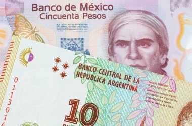 Meksika 'dan gelen 50 pezoluk pembe bir banknotun makro görüntüsü Arjantin' den gelen renkli 10 peso banknotla eşleştirildi. Makro çekimde yakın çekim.