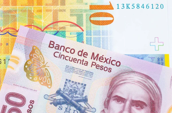 一张墨西哥面额为50比索的粉色塑料钞票的宏观图片 与一张10瑞士法郎的黄色钞票搭配在一起 在宏观上拍的特写 — 图库照片