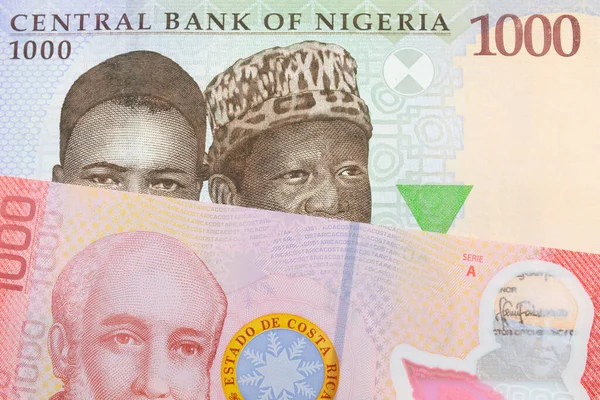 stock image A macro image of a blue, purple and green one thousand  naira note from Nigeria paired up with a colorful red one thousand colones bank note from Costa Rica.  Shot close up in macro.