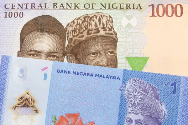 ナイジェリアの青 緑の1 000ナイラ紙幣のマクロ画像とマレーシアの青 プラスチック製の1リンギット銀行券のメモが組み合わされています マクロでショットを閉じる — ストック写真