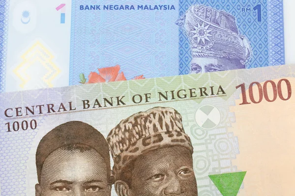 ナイジェリアの青 緑の1 000ナイラ紙幣のマクロ画像とマレーシアの青 プラスチック製の1リンギット銀行券のメモが組み合わされています マクロでショットを閉じる — ストック写真
