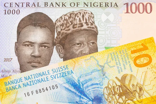 ナイジェリアの青 緑の1 000ナイラ紙幣と黄色のスイス10フラン紙幣のマクロ画像 マクロでショットを閉じる — ストック写真