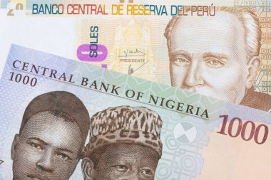 Nijerya 'dan gelen mavi, mor ve yeşil bir 1000 nairanın makro görüntüsü, Peru' dan gelen bej, yirmi sol banknotuyla eşleştirildi. Makro çekimde yakın çekim.