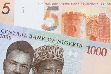 Nijerya 'dan gelen mavi, mor ve yeşil bin nairalık bir banknotun makro görüntüsü Belarus' tan gelen beş ruble turuncu banknotla eşleştirildi. Makro çekimde yakın çekim.