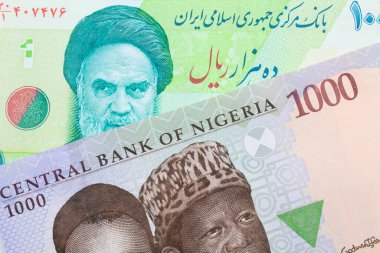 Nijerya 'dan mavi, mor ve yeşil bin nairalık bir banknotun makro görüntüsü İran' dan gelen mavi ve yeşil on bin riyal banknotla eşleştirildi. Makro çekimde yakın çekim.