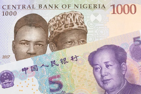 ナイジェリアの青 緑の1 000ナイラ紙幣のマクロ画像と中国の紫 白の5元銀行券のメモがペアになっています マクロでショットを閉じる — ストック写真