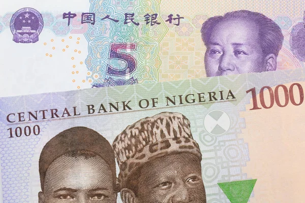 ナイジェリアの青 緑の1 000ナイラ紙幣のマクロ画像と中国の紫 白の5元銀行券のメモがペアになっています マクロでショットを閉じる — ストック写真