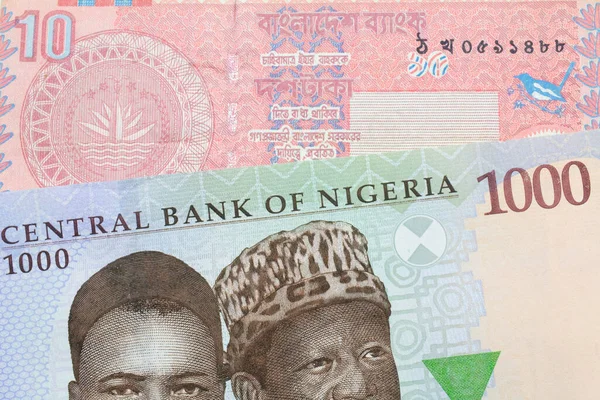 ナイジェリアの青 緑の1 000ナイラ紙幣のマクロなイメージとバングラデシュの赤10タカ紙幣が対になっている マクロでショットを閉じる — ストック写真