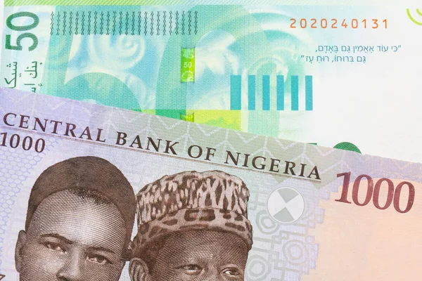 ナイジェリアの青 緑の1 000ナイラ紙幣のマクロなイメージと イスラエルの緑と白の50シェケル紙幣とが対になっている マクロでショットを閉じる — ストック写真