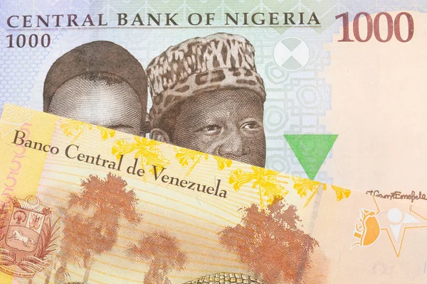 ナイジェリアの青 緑の1 000ナイラ紙幣のマクロ画像と ベネズエラのカラフルな黄色の5つのボリバル銀行券のメモが組み合わされています マクロでショットを閉じる — ストック写真
