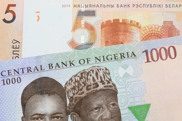 ナイジェリアの青 緑の1000ナイラのノートのマクロ画像は ベラルーシのオレンジの5ルーブル紙幣と対になっています マクロでショットを閉じる — ストック写真