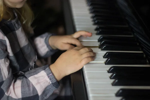 Little girl play piano,kids hands on piano keyboard close up,homeschooling,musical education.Growing talented child.Daily routine for toddler,side view of childs hands and piano.