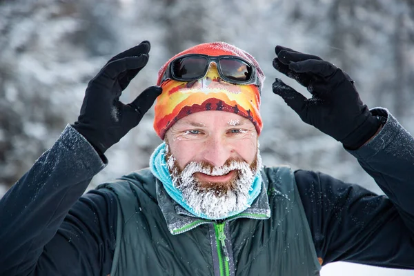 trail runner with frozen beard training in winter landscape