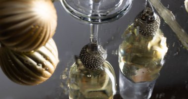 Yeni yıl arkaplanına yansıyan iki şampanya kadehi.