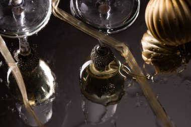 Yeni yıl arkaplanına yansıyan iki şampanya kadehi.