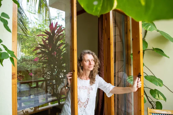 Kobieta Otwierając Drzwi Tropikalnego Ogrodu — Zdjęcie stockowe