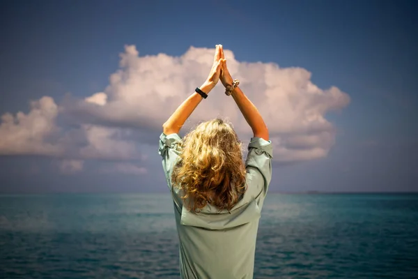 女人在海面上做瑜伽对抗日落云 — 图库照片