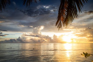 Tropikal bir adada denizin üzerinde inanılmaz bir gün batımı.
