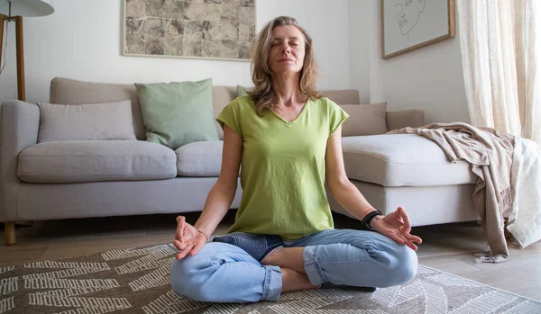 自宅の居間で瞑想している女性は — ストック写真