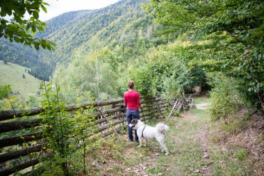 Kırsalda köpekle gezen bir kadın.