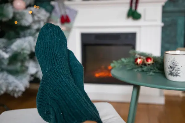 穿着毛袜的女人在壁炉前取暖 — 图库照片
