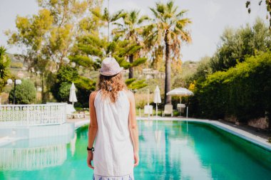 Yaz tatilinde havuz başında bir kadın.