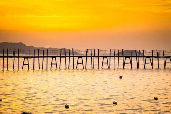 日落时海上的木制行人天桥 — 图库照片