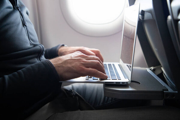 man working on a laptop during flight