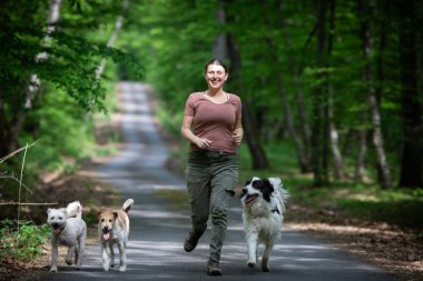 Ormanda köpekleriyle mutlu bir kadın.