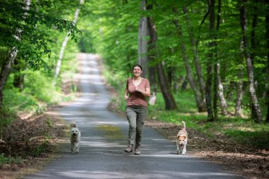 Ormanda köpekleriyle mutlu bir kadın.