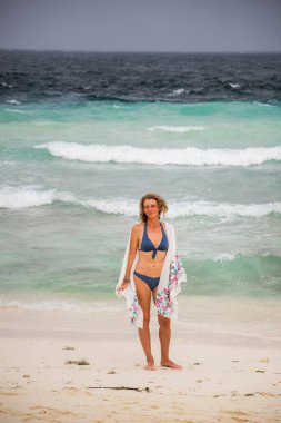 Güzel bir kadın tropik bir plajda eğleniyor.