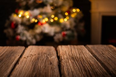 Ahşap masa ve arka planda bulanık Noel ağacı 