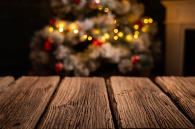 Ahşap masa ve arka planda bulanık Noel ağacı 