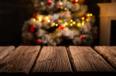 Ahşap masa ve arka planda bulanık Noel ağacı 