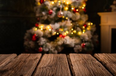 Ahşap masa ve arka planda bulanık Noel ağacı 
