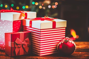 Festival kırmızı hediye kutuları beklemede yanan şömine ve Noel ağacı - rahat ev