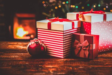 Festival kırmızı hediye kutuları beklemede yanan şömine ve Noel ağacı - rahat ev
