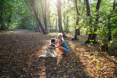 Mutlu beyaz köpek bahar ormanında oynuyor.