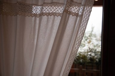 Pencerenin perdesi kış günü kapalı.