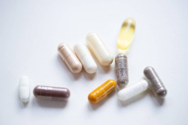 Beyaz arka planda ilaç ve takviye kapsülleri almak