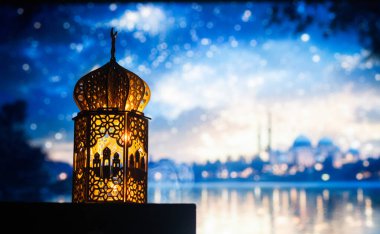 Gece yanan mum ve arka planda cami ile süslenmiş Arapça bir fener. Müslüman kutsal ayı Ramazan Kareem için kutlama kartı.